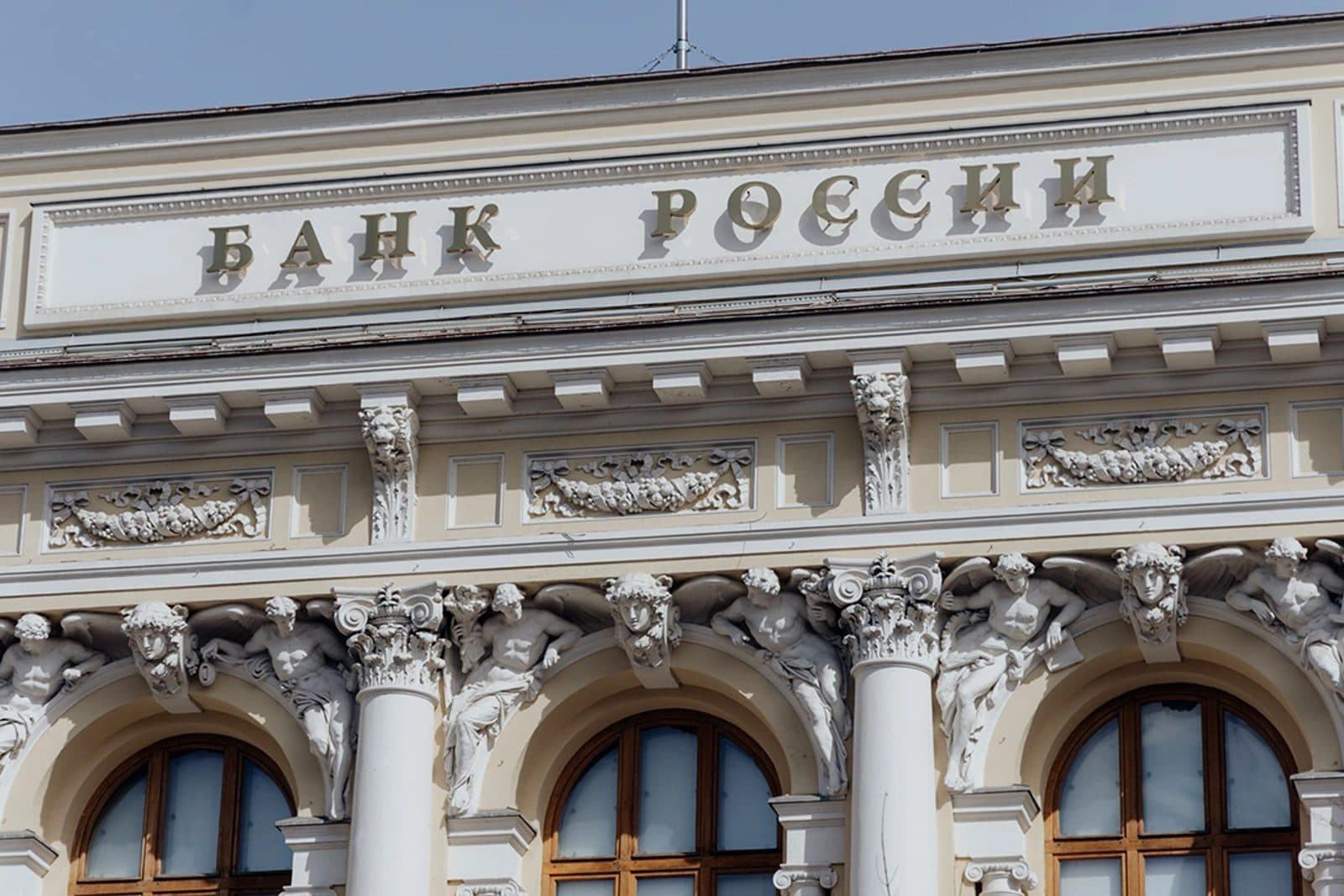 Фасад здания Банка России с лепниной и скульптурами над арочными окнами
