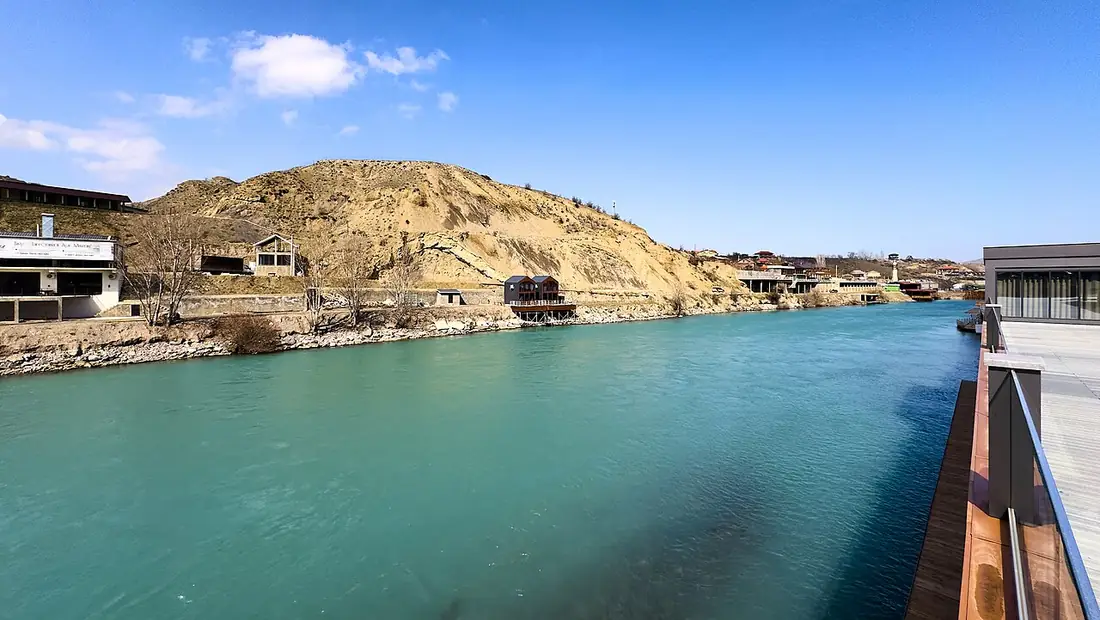 Сулак в районе Ново-Зубутли: бирюзовая вода, песчаный склон и постройки на берегу
